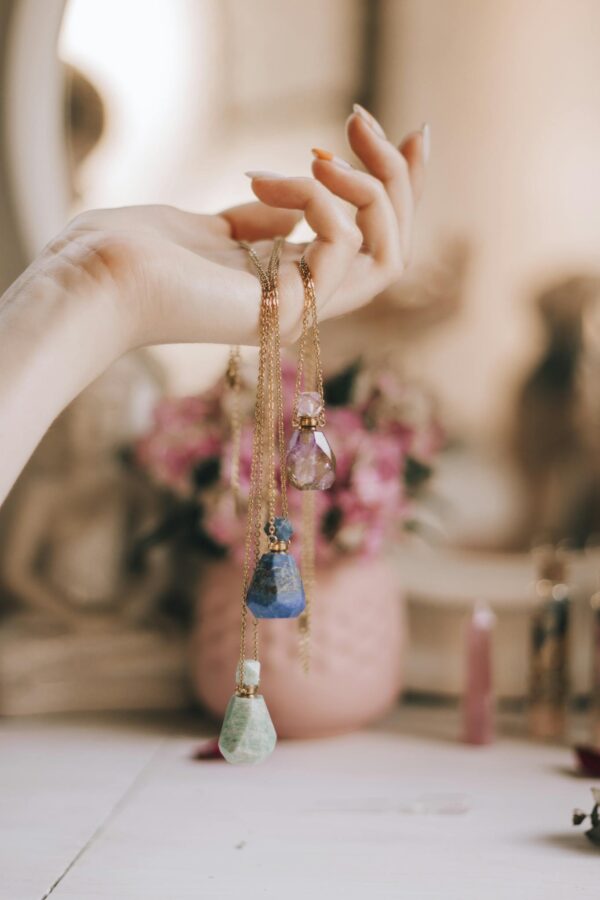 Woman Hand Holding Crystal Bottles Jewelry